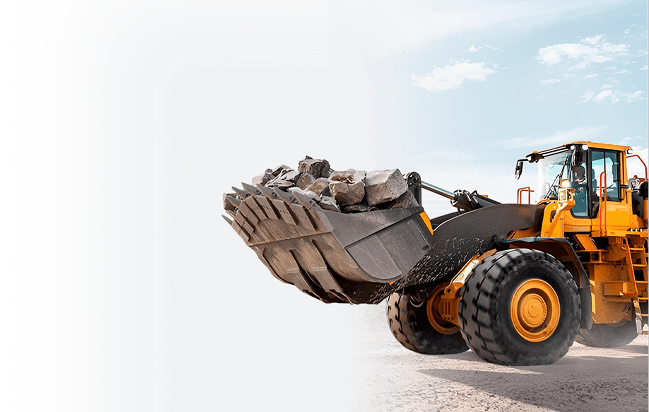 Yellow wheel loader bucket filled with aggregate on a construction site